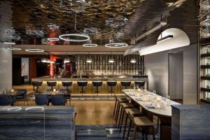 a restaurant with a long table and a bar at W Montreal in Montreal