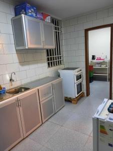 a kitchen with white cabinets and a sink at Elira 2 chambres rez-de-chaussée in Kinshasa