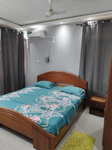 a bedroom with a bed with a blue comforter at Elira 2 chambres rez-de-chaussée in Kinshasa