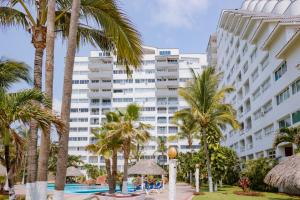 a hotel with palm trees in front of a building at Casa Lily in Mazatlán