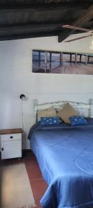 a bedroom with a blue bed and a table and a window at cabaña las casuarinas in San Clemente del Tuyú