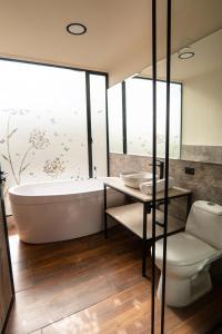 a bathroom with a tub and a toilet and a sink at Refugio Piedra Parada in Tona +79 photos