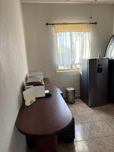 een kantoor met een bureau en een koelkast in een kamer bij Habitacion Arboleda in Saltillo