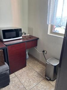 a microwave sitting on top of a wooden desk at Habitacion Arboleda in Saltillo