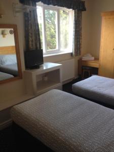 een hotelkamer met 2 bedden en een spiegel bij The Miners Arms in Leeds