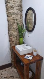 a bathroom with a sink and a mirror on a table at Casa Verde no Centro Histórico in Paraty +40 photos