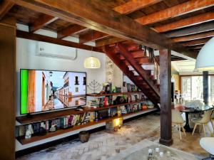 a living room with a tv and a book shelf at Casa Verde no Centro Histórico in Paraty