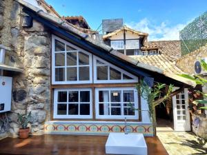 a house with a large window on the side of it at Casa Verde no Centro Histórico in Paraty