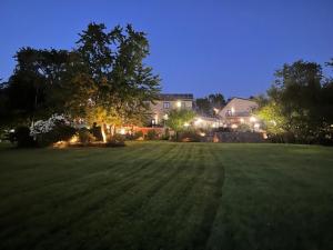 a large field of grass with a house in the background at Long Lake Escape in Hammonds Plains