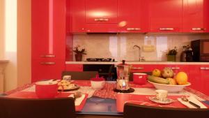 una cocina con armarios rojos y una mesa con fruta. en House Rouge by Holiday World, en Zoagli