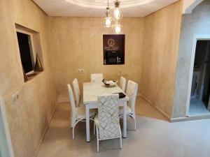 a dining room with a white table and chairs at Quadra Sphere in Tamraght Ouzdar