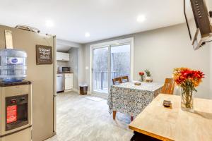 a kitchen and dining room with a table and a refrigerator at 2 Mi to Gillette Stadium Foxborough Retreat! in Foxborough