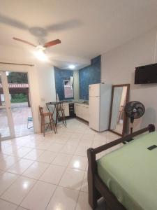 una cucina e un soggiorno con frigorifero e tavolo di kitnet & Suítes Aloha Beach Bertioga a Bertioga
