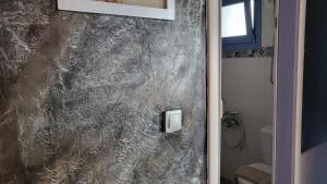 a bathroom with a marble wall with a shower at Hermes Korifi Suites private apartment in Hersonissos +17 photos