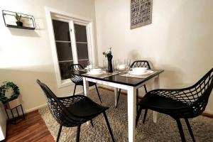 una mesa de comedor con sillas negras y una mesa con flores. en Stavanger Bnb - billiard Sauna, en Stavanger 20 fotos más