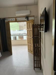 a room with a refrigerator and a door with a television at Belas Praias Itacaré 2 in Itacaré