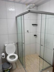 a bathroom with a toilet and a glass shower at Belas Praias Itacaré 2 in Itacaré