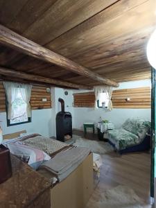 a bedroom with two beds in a room with wooden ceilings at Brvnara Gromki - Mountain house in Han Pijesak