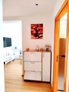 a room with a white dresser and a tv at appartement 2 chambres cosy luxe in Sale