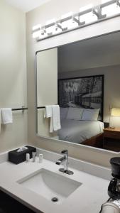 a bathroom with a sink and a large mirror at Super 8 by Wyndham Hampshire IL in Hampshire +17 photos