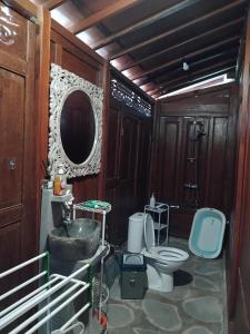 un bagno con un water, un lavandino e uno specchio di Lotus cottage a Bedahulu