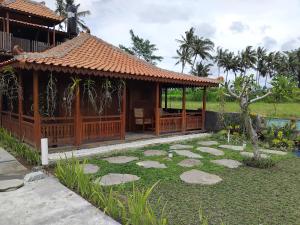 un gazebo con un sentiero in pietra nel cortile di Lotus cottage a Bedahulu