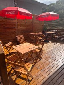 two tables and chairs with umbrellas on a deck at Pousada Recanto do Canário 2 in Governador Celso Ramos