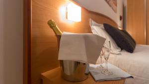 a bottle of champagne on a table next to a bed at Hotel Mare Blu -- boutique in Pineto