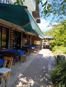a restaurant with blue tables and chairs on a patio at Brvnara Gromki - Mountain house in Han Pijesak
