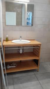 a bathroom with a sink and a mirror at Hébergement T3 COSY WOUSIRE in Les Abymes