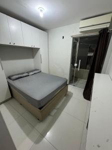 ein kleines Schlafzimmer mit einem Bett und einem Fenster in der Unterkunft Casa da margo in Florianópolis