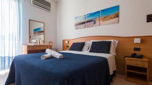 a bedroom with a large bed with a blue blanket at Hotel Mare Blu -- boutique in Pineto