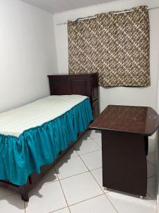 シャパダ・ドス・ギマランイスにあるCasa Tranquila e Familiar Para Temporada!のベッドと机のある小さな部屋