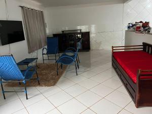 シャパダ・ドス・ギマランイスにあるCasa Tranquila e Familiar Para Temporada!のベッド、椅子、テレビが備わる客室です。