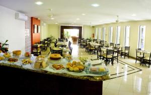 a buffet of food in a room with tables and chairs at Benvenuto Palace Hotel in Governador Valadares