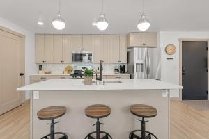 una cocina con una isla grande con 3 taburetes en Pinyon Pines #103 condo, en Hurricane