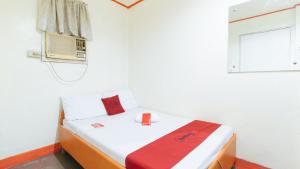 a small room with a bed and a window at RedDoorz @ Eros Travellers Pensione in Iloilo City +14 photos