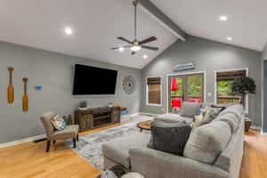 un salon avec un canapé et une télévision à écran plat dans l'établissement 4bd Waterfront House in Lake Lanier with HotTub, FirePit, Wifi, Ping Pong and 2 Kaya, à Gainesville