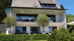 a large white house with a large balcony at Landhaus Mettenberg in Eslohe