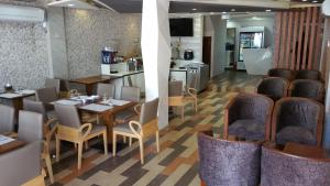 a restaurant with tables and chairs and a kitchen at Vista Beach Retreat in Hulhumale
