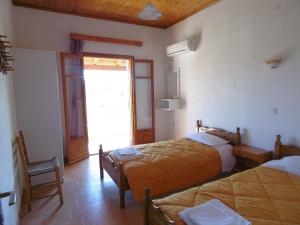 1 dormitorio con 2 camas y puerta a un patio en Apartments Elli - Nikos, en Ýpsos