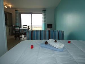 ein Schlafzimmer mit einem Bett mit zwei roten Kerzen darauf in der Unterkunft Studio vue mer à Notre-Dame-de-Monts - Animaux OK, Parking - 2 pers. - FR-1-540-292 in Notre-Dame-de-Monts