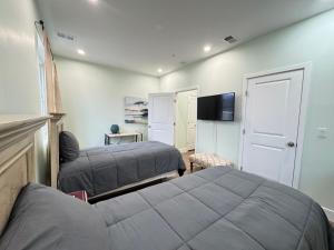 ein Schlafzimmer mit zwei Betten und einem Flachbildfernseher in der Unterkunft LUX Spacious Townhouse 4BR in DC in Washington