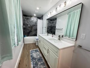 ein Badezimmer mit Waschbecken und Spiegel in der Unterkunft LUX Spacious Townhouse 4BR in DC in Washington + 34 Fotos