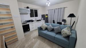 圣菲利普Blessings Haven的带蓝色沙发的客厅和厨房