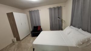 a bedroom with a large white bed and curtains at Blessings Haven in Saint Philip