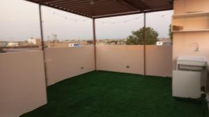 an empty room with green grass in a building at CARDOS HOSTAL in Pisco