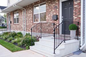 a brick house with stairs and a black door at Hidden Gem 2 in Norristown