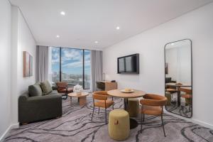 a living room with a couch and a table and chairs at Veriu Macquarie Park in Sydney