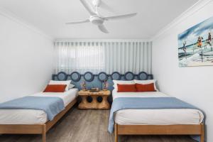 een slaapkamer met twee bedden en een plafondventilator bij Amadiya Marina Nelson Bay in Nelson Bay